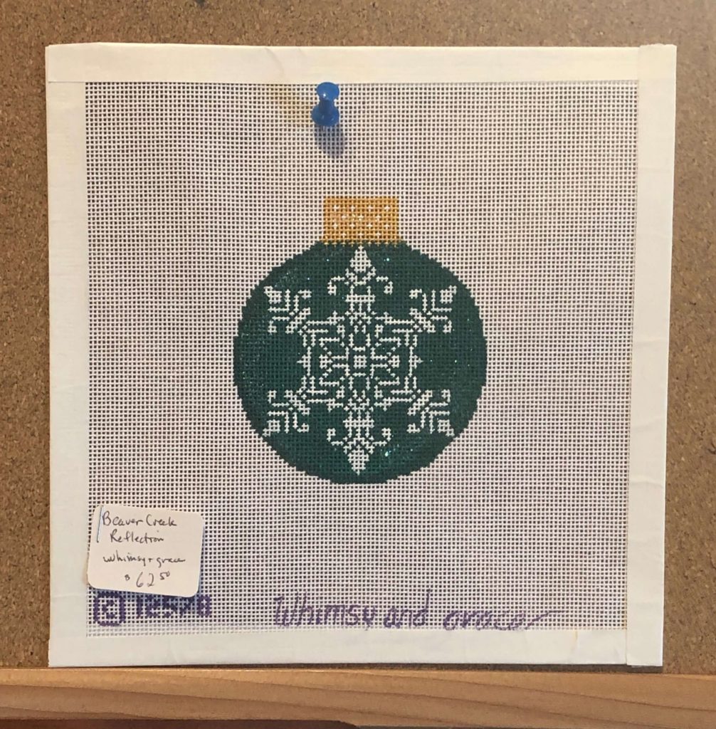 a needlepoint canvas with a hand-painted Christmas ornament