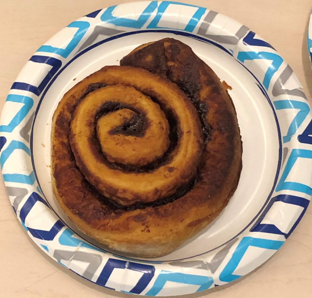 a jumbo cinnamon roll that is large enough to fill an 8-inch plate