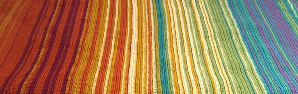 a crocheted temperature blanket in which stripes represent different weather changes