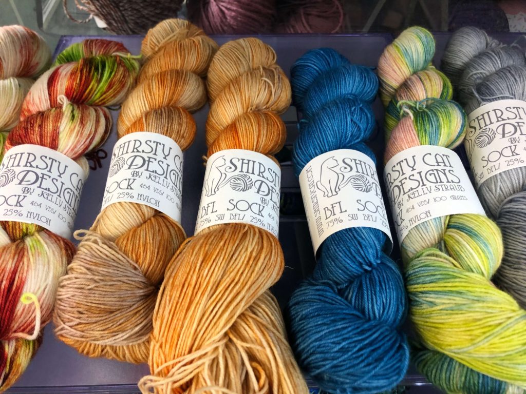 several hanks of Shirsty Cat BFL sock yarn on a clearance shelf
