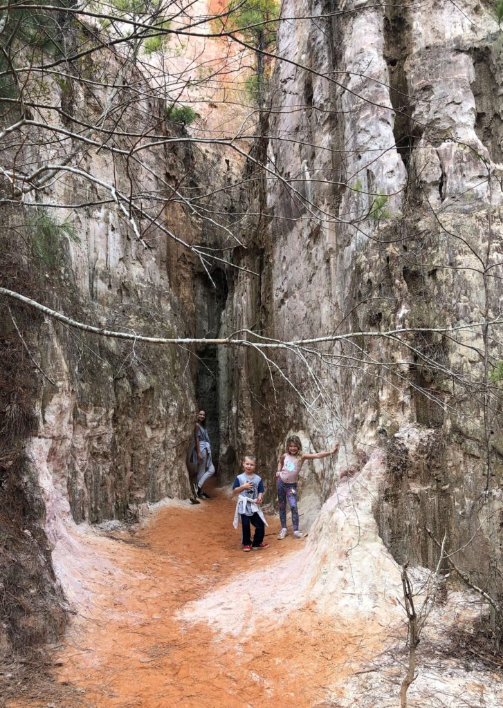 three children pose at the base of Providence Canyon,