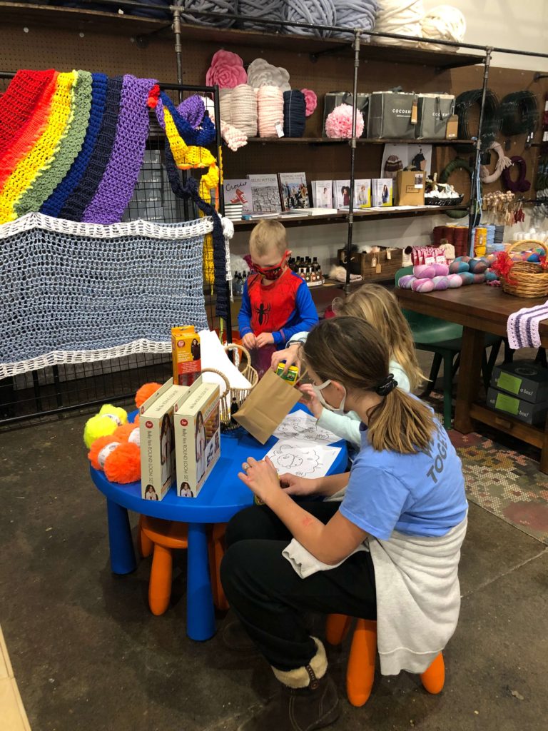 three children color at a small table at Rocktown Yarn