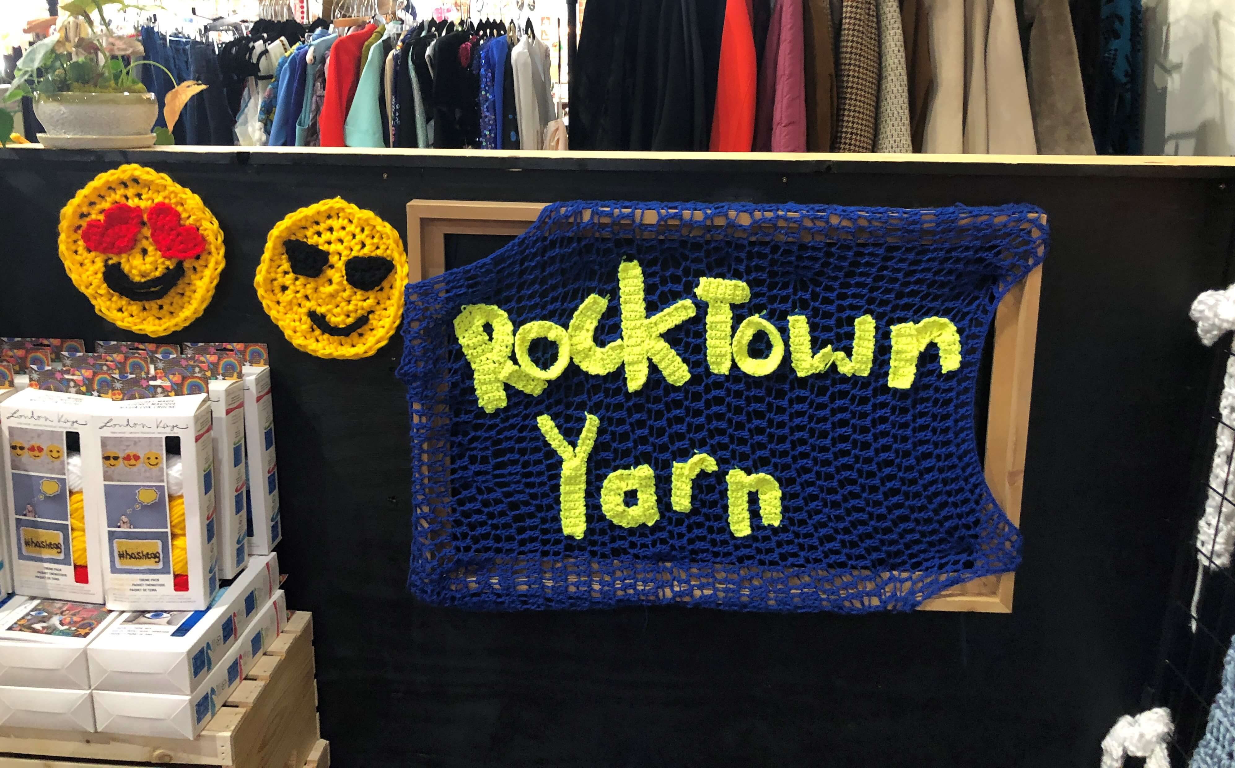 a handmade yarn sign reads "Rocktown Yarn" and is flanked by smiling and heart-eyed emojis