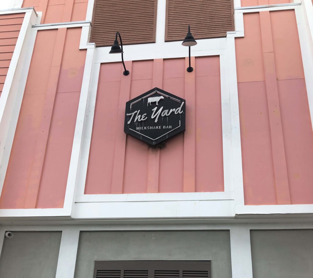 the exterior of The Yard Milkshake Bar features a cow on the sign