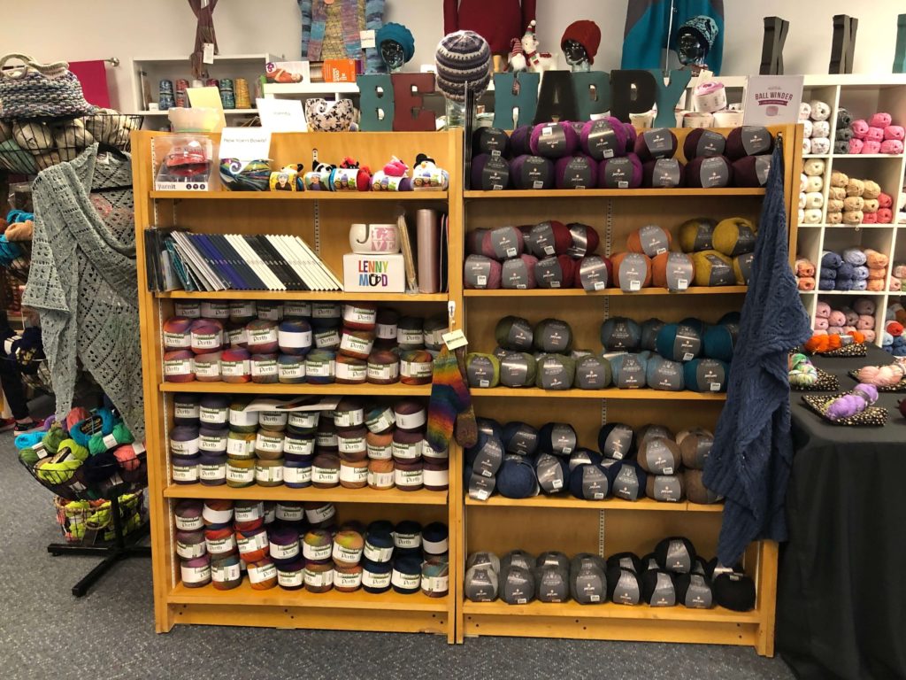 stacks of cakes and balls of yarn line shelves
