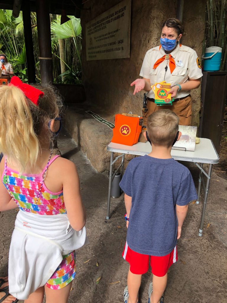 a Wilderness Explorer badge guide explains to three children how the Wilderness Explorers program works