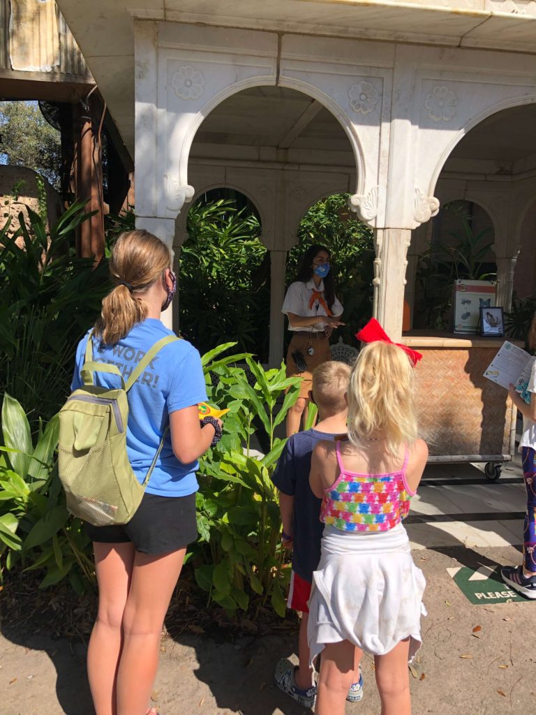 a Wilderness Explorer badge guide explains to several families about how human activity impacts animals