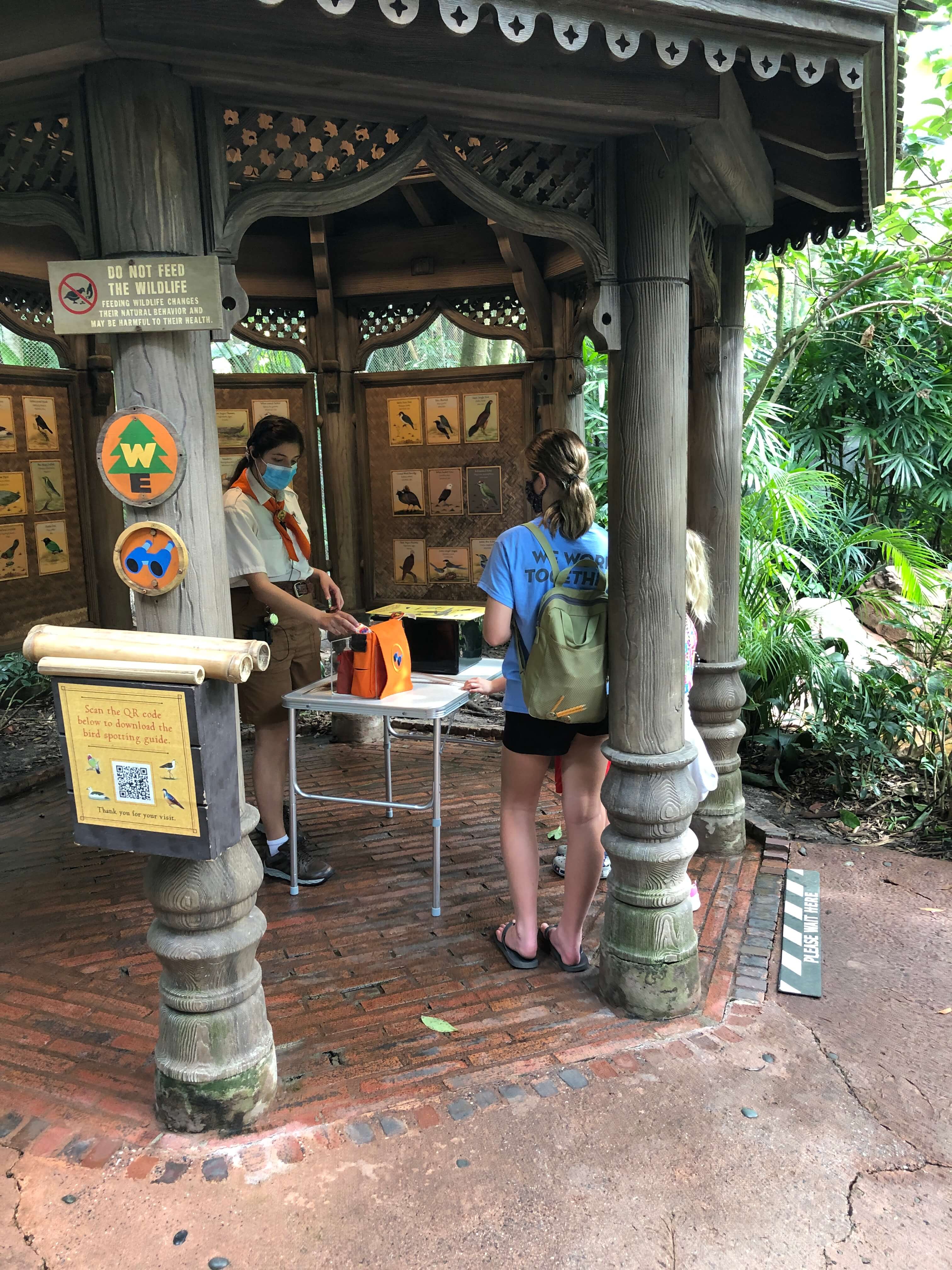 a Wilderness Explorer badge guide explains to three children how human activity impacts animals