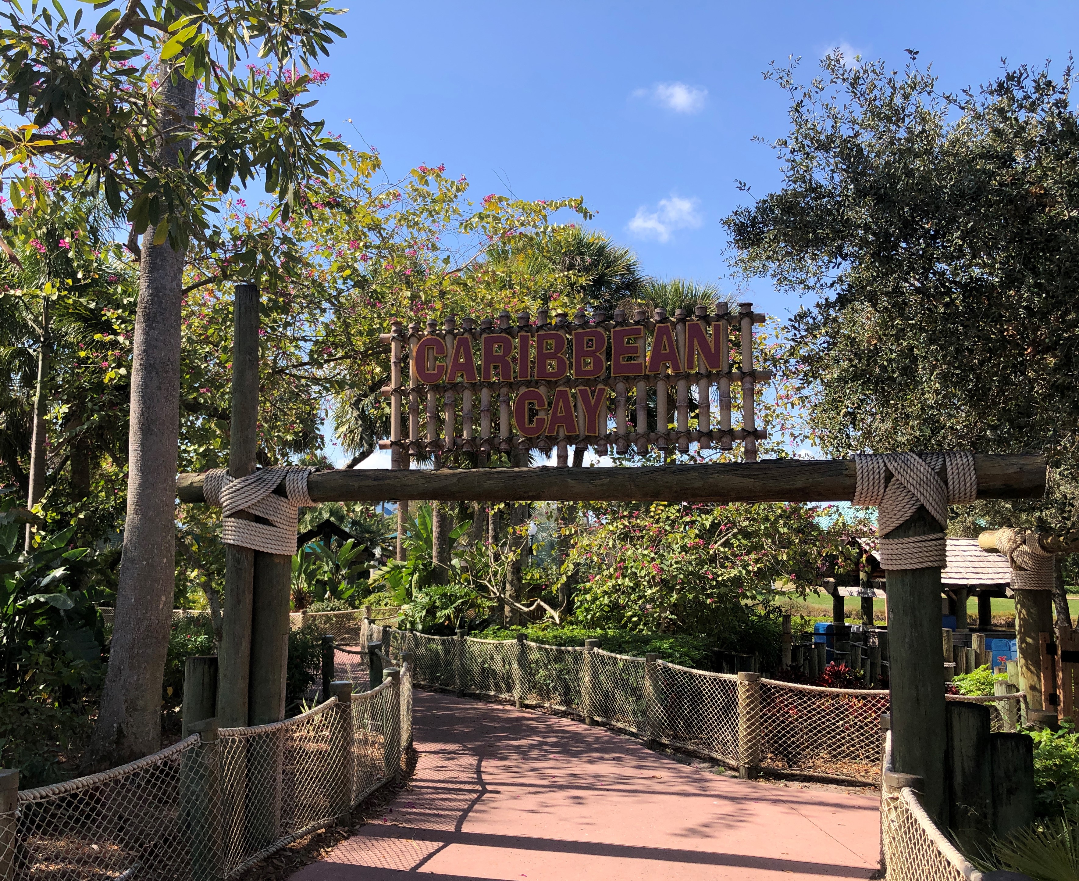 a sign marks the entrance to Caribbean Cay, an island with thick foliage and rope fences