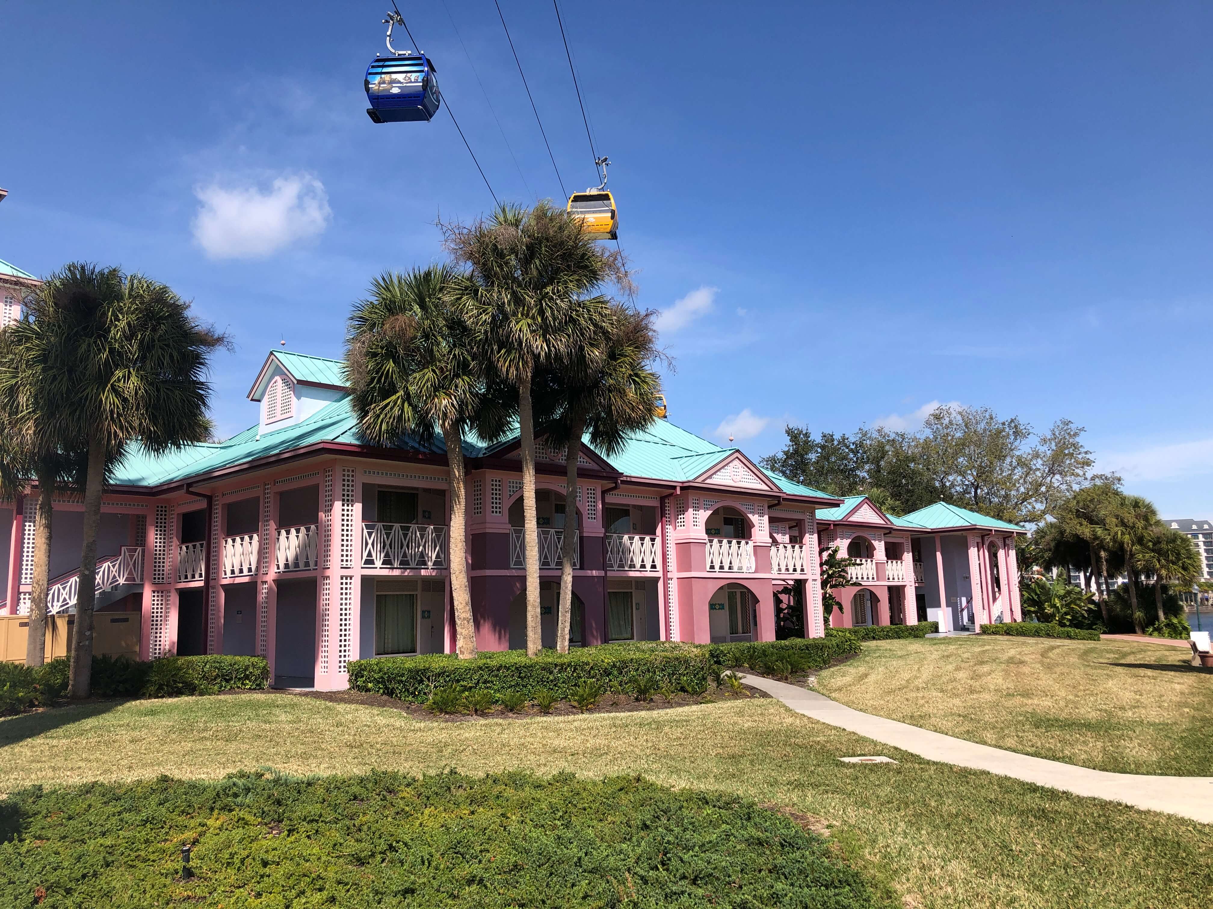 gondolas pass over a Caribbean-style building surrounded by palm trees