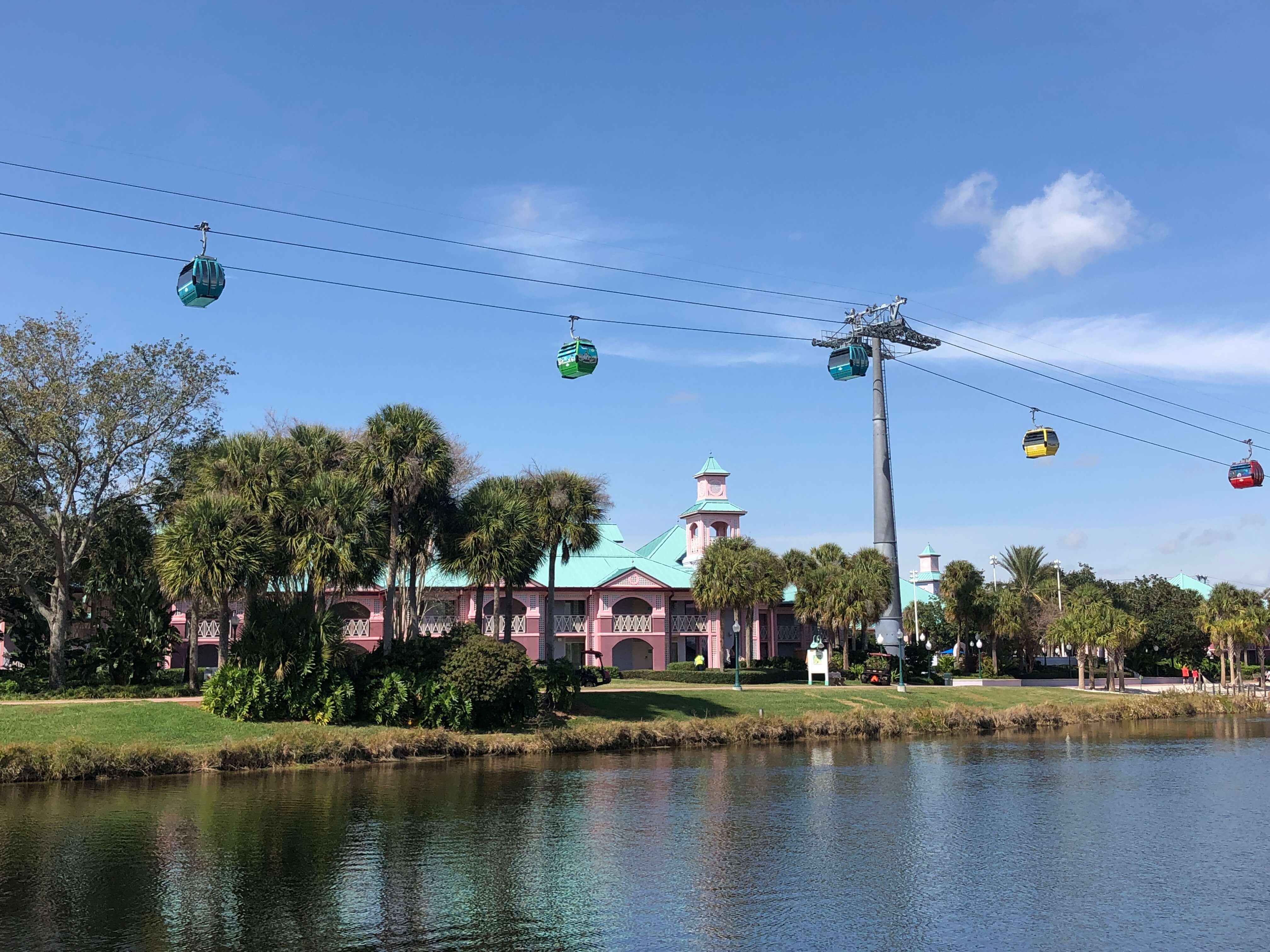 gondolas pass over a Caribbean-style building surrounded by palm trees