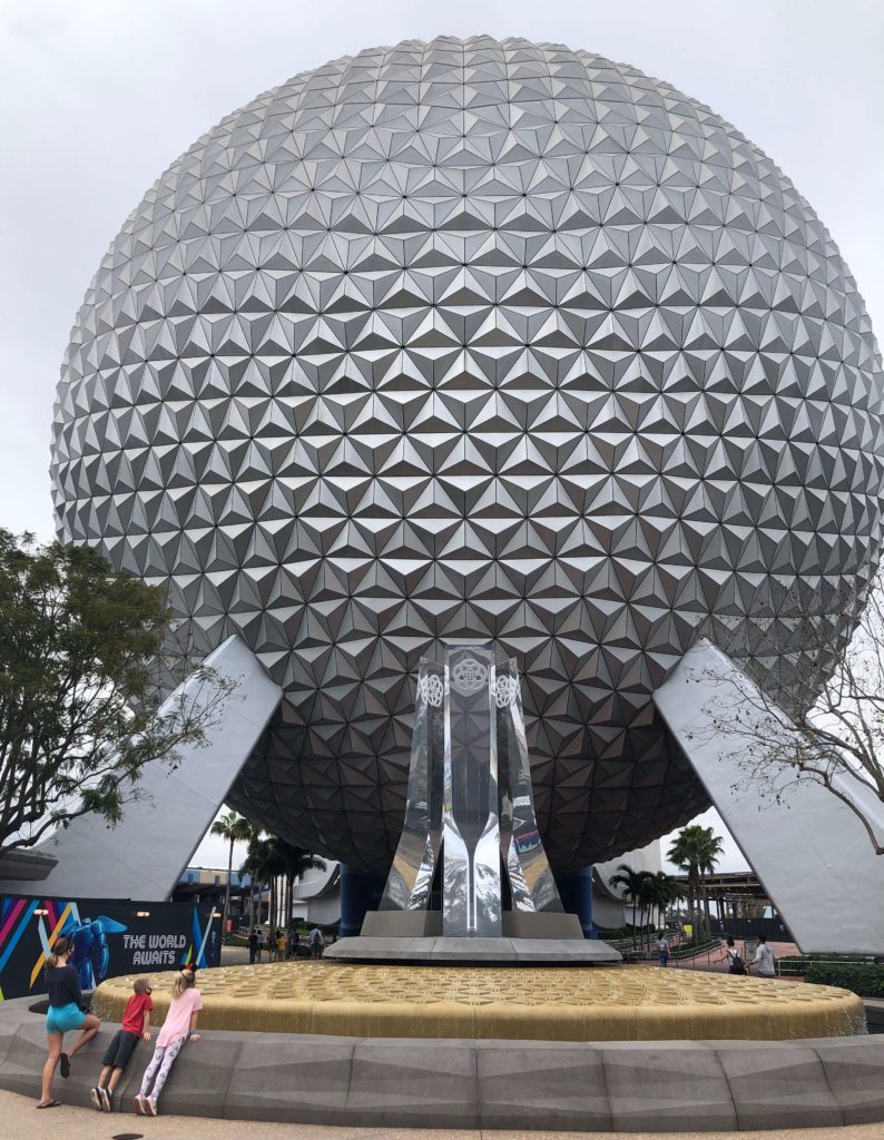 three children look at a large geodesic dome (Spaceship Earth)
