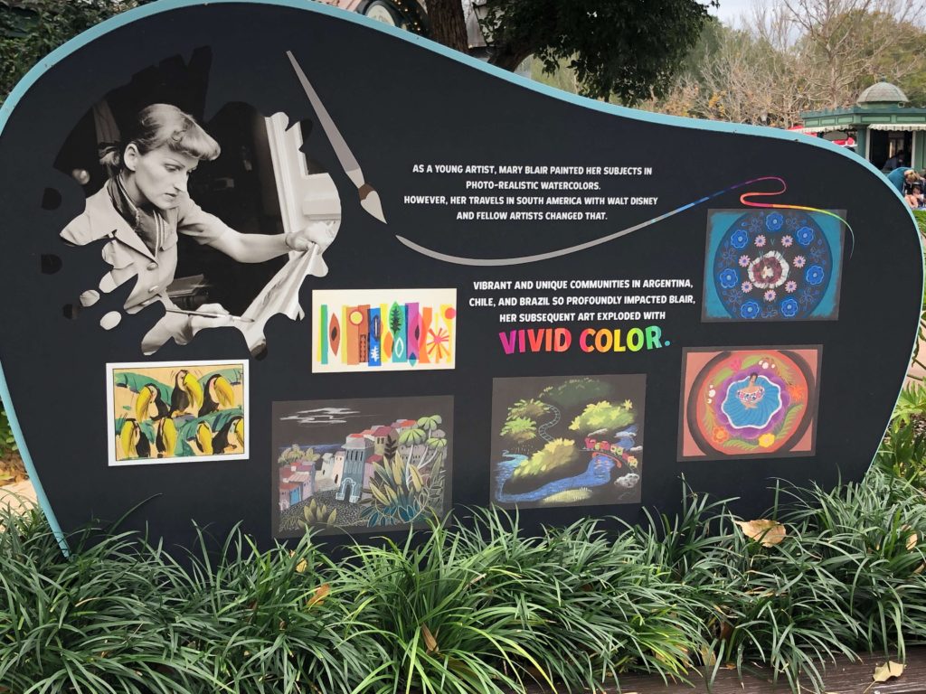 a sign featuring Mary Blair and her artwork reads: Vibrant and unique communities in Argentina, Chile, and Brazil so profoundly impacted Blair, her subsequent art exploded with vivid color.