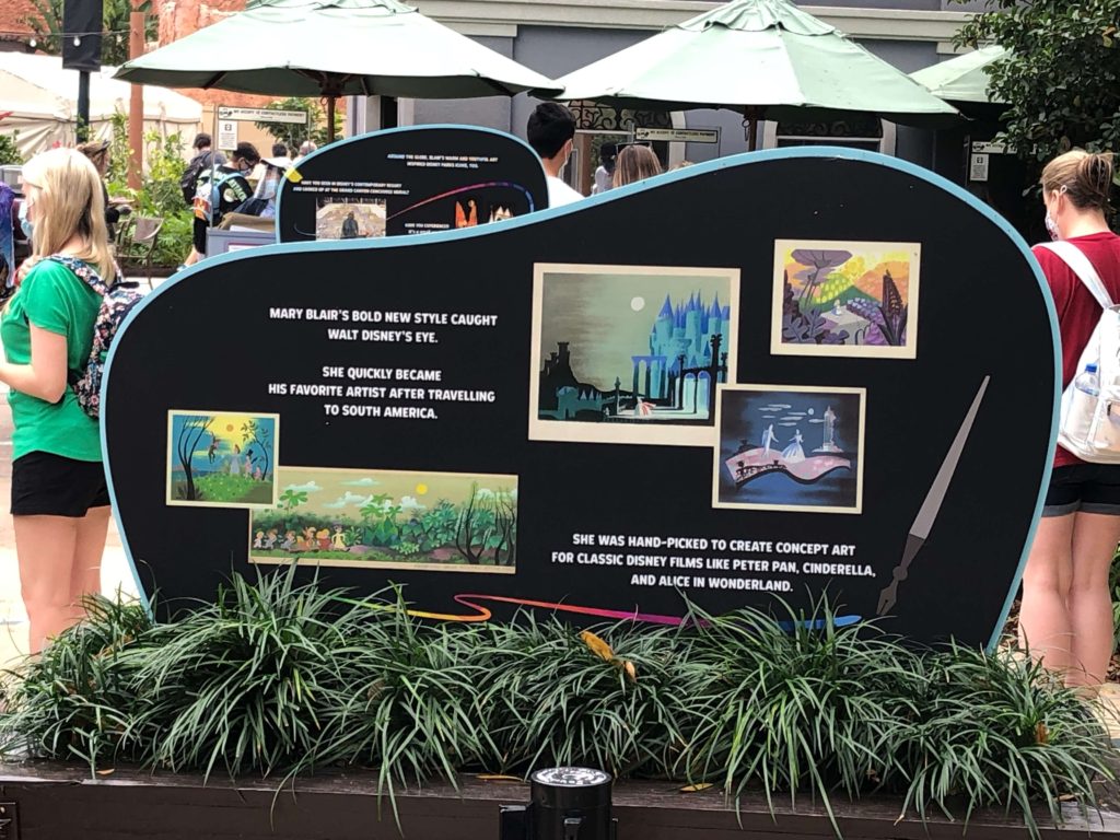 A sign featuring Mary Blair's artwork for Walt Disney reads, "Mary Blair's bold new style caught Walt Disney's eye."