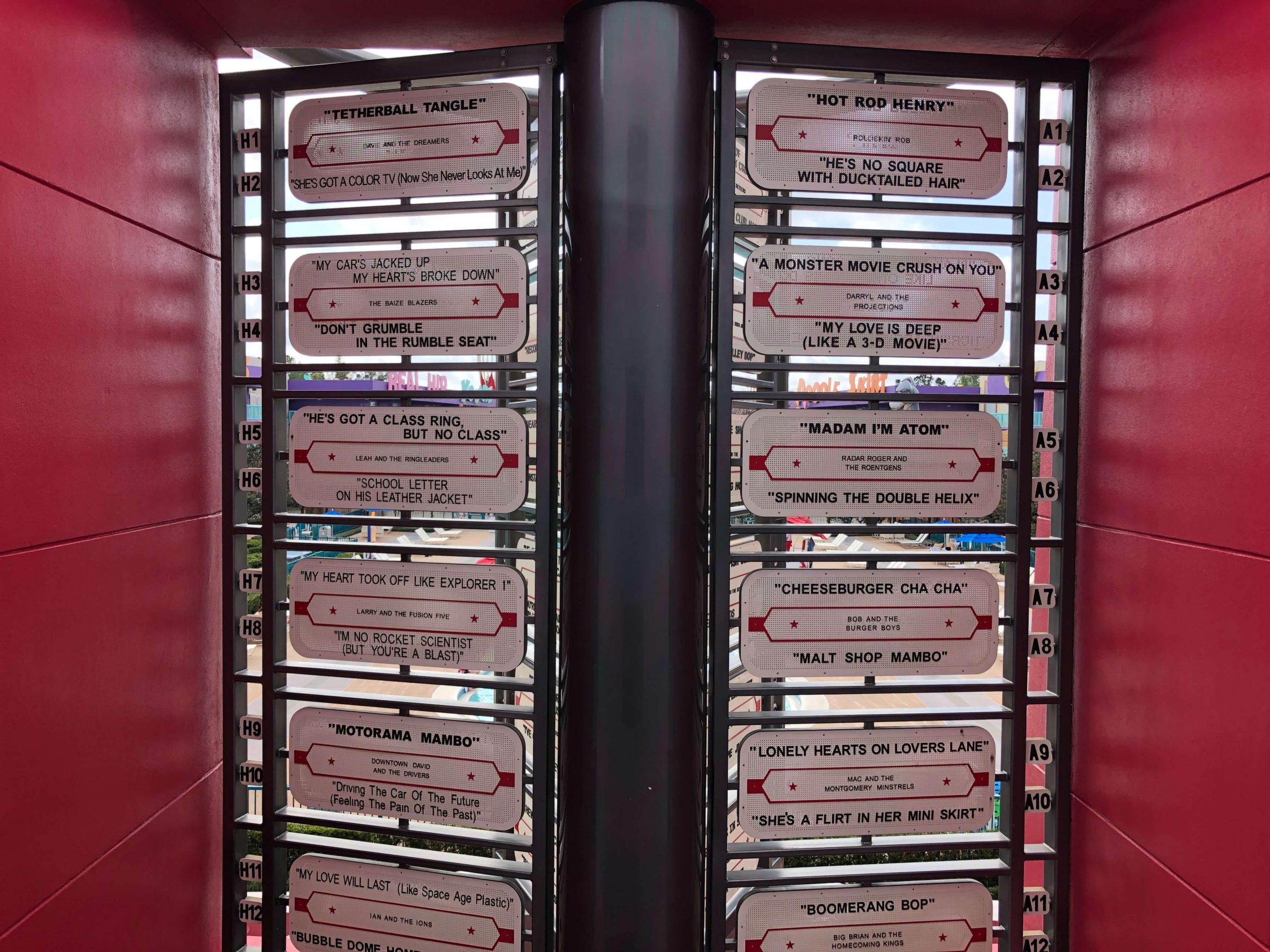 a close-up of a gigantic jukebox reveals names of songs like "Cheeseburger Cha Cha" and Lonely Hearts on Lovers Lane"