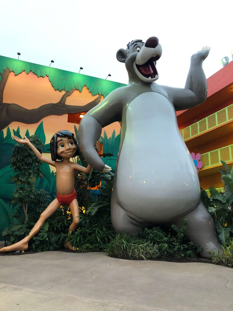 larger-than-life replicas of Mowgli and Baloo in front of the 1960s section of Pop Century Resort