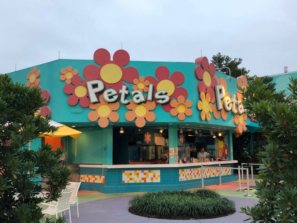 a pool bar decorated with large round flowers reads "Petals"