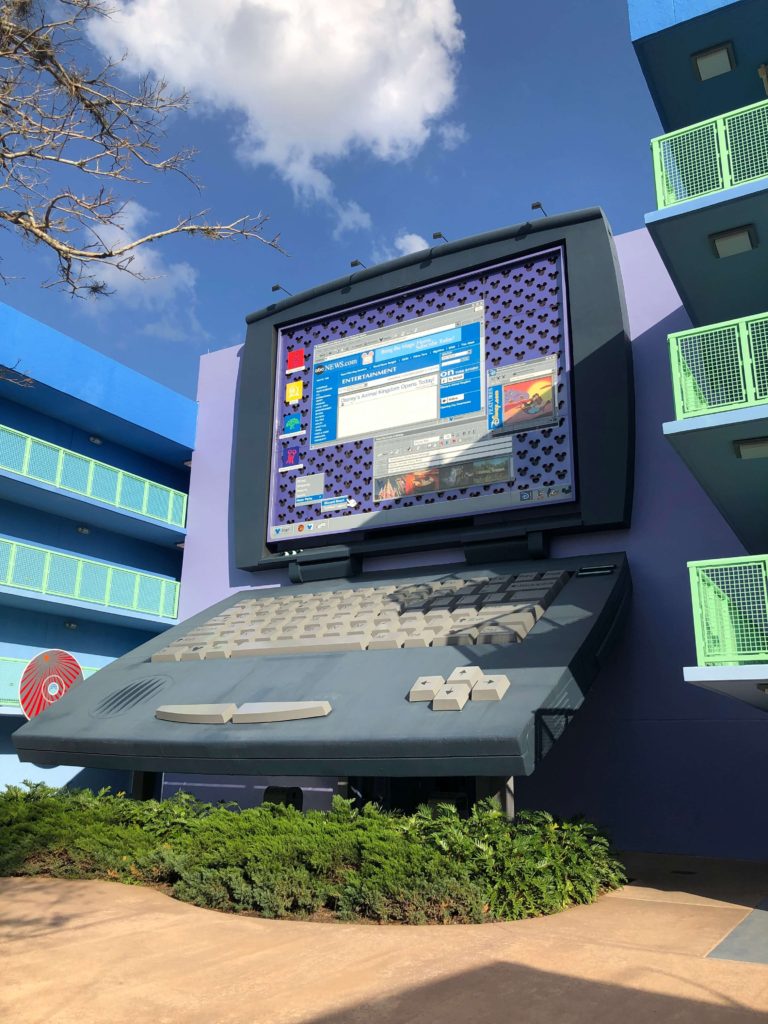 a four-story laptop computer with a Mickey Mouse background and several open windows