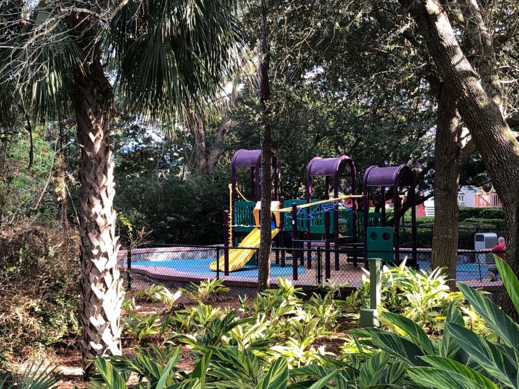 an empty playground as seen through the surrounding landscaping