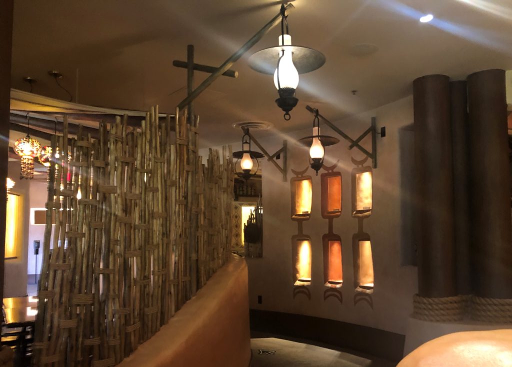 dried, bound bamboo and lanterns frame the dimly lit entryway to Sanaa