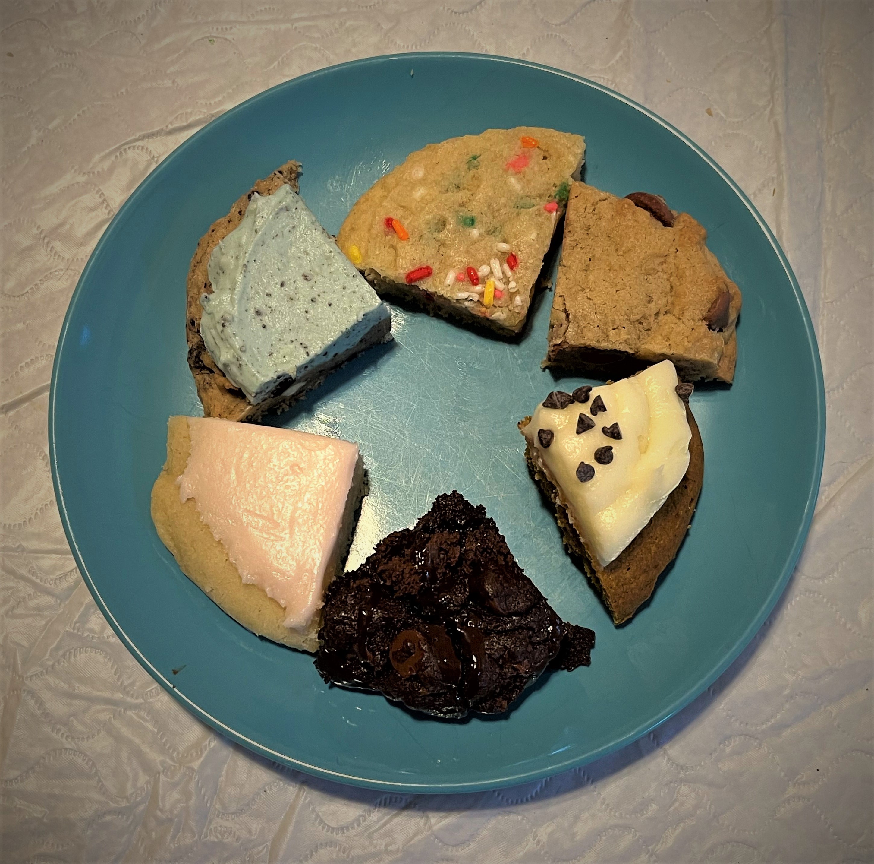 quarter-sized pieces of six different cookies on a blue plate