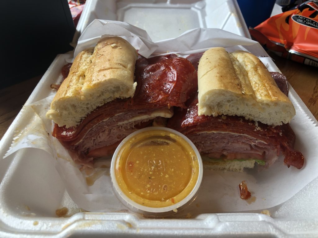 a massive Italian sandwich in a clamshell to-go container from The Battlefield Country Store 