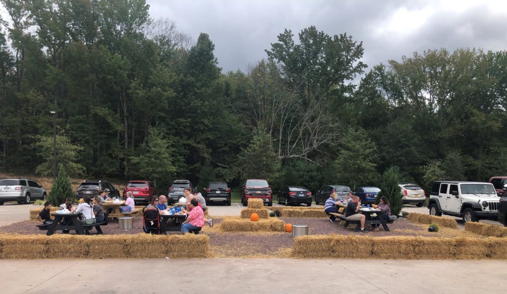 an outdoor dining area at The Battlefield Country Store is lined with hay bales and filled with picnic tables 