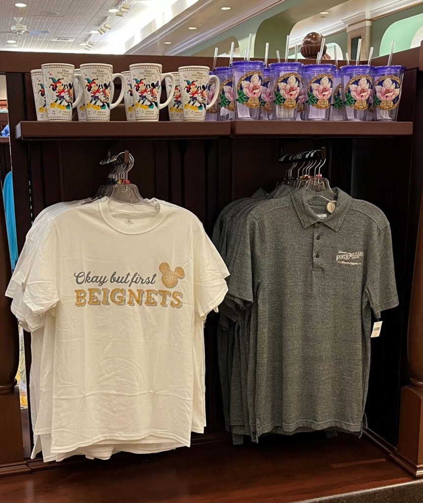 Port Orleans merchandise at Jackson Square Gifts & Desires, including a t-shirt that reads "But first, beignets"
