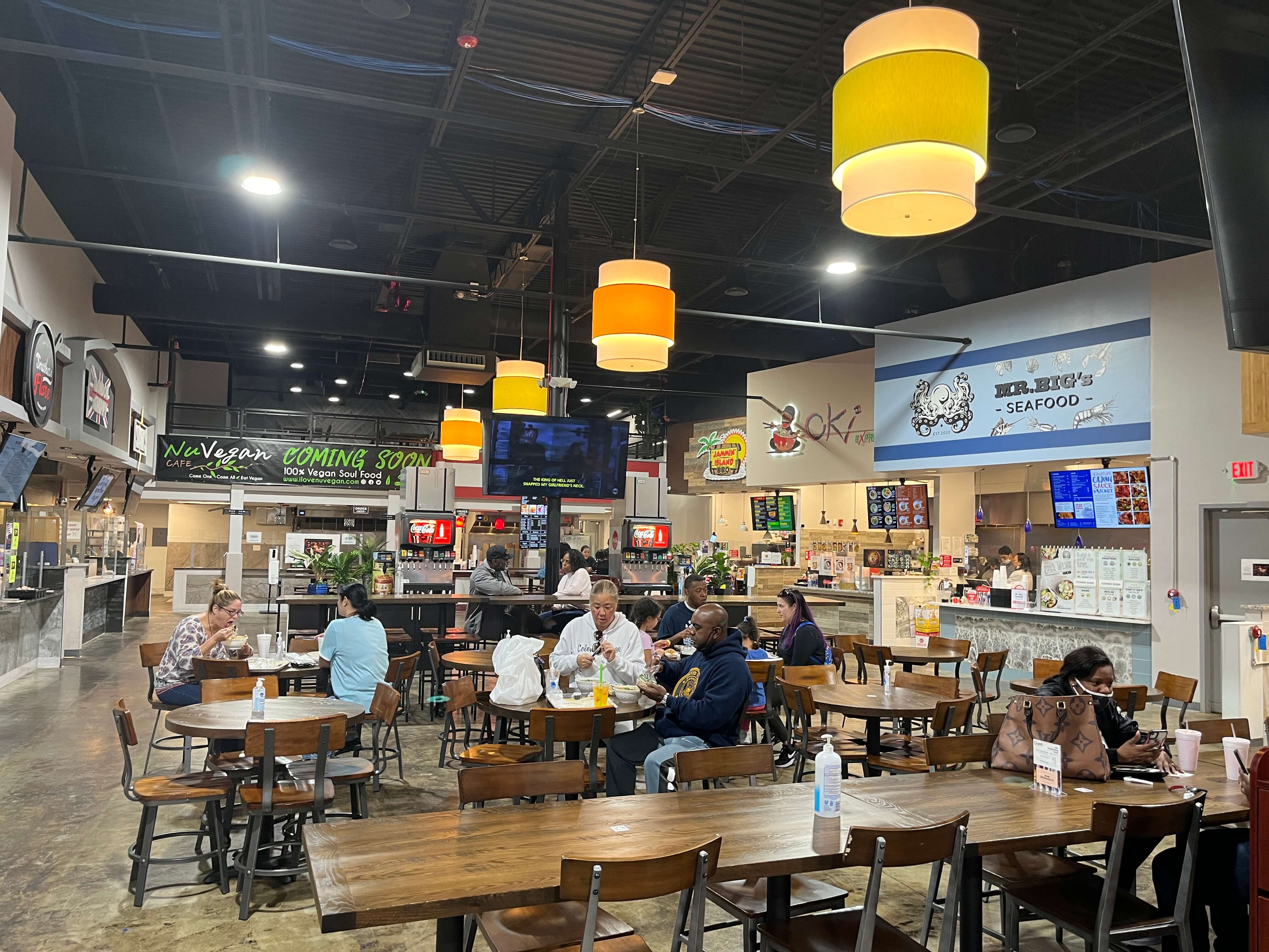 diners at dozens of tables enjoy lunch from Epiq Food Hall's vendors
