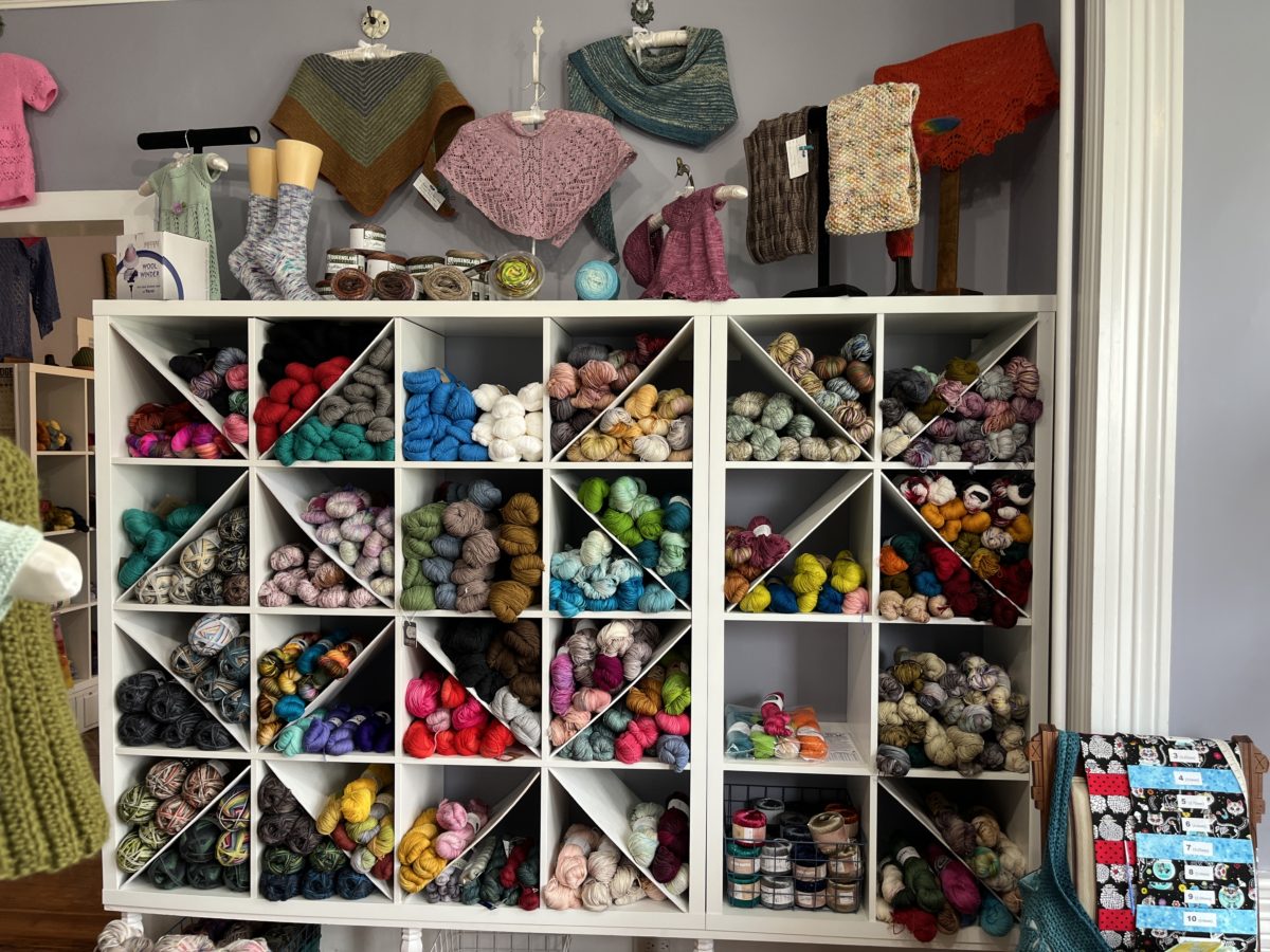 shelves stuffed with yarn and sample knits at Two Rivers yarns local yarn shop