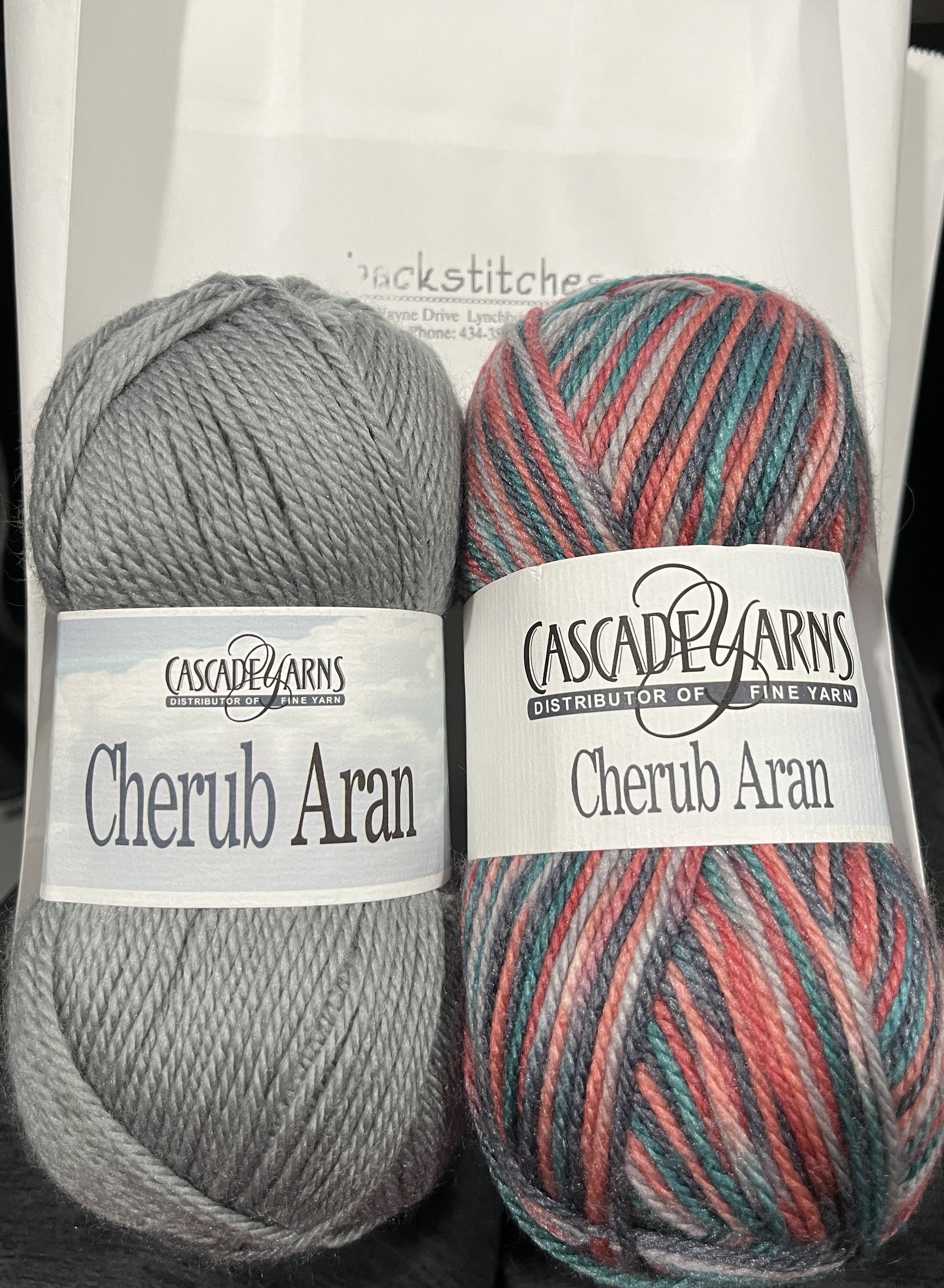 two coordinating skeins of Cherub Aran yarn by Cascade Yarns