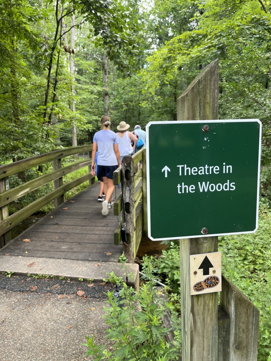 a sign directs the audience over a bridge at the Children's Theatre in the Woods at Wolf Trap in Vienna, Virginia