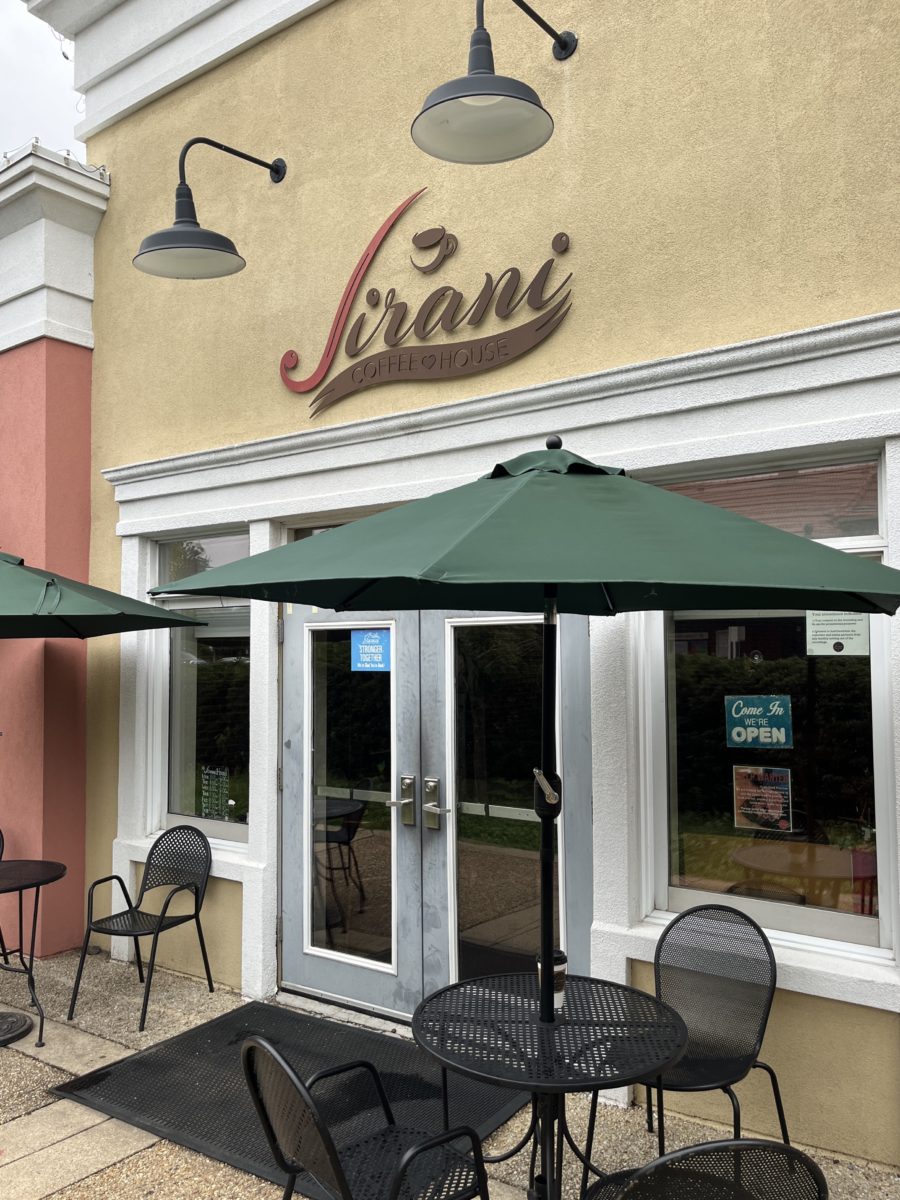 the exterior of Jirani Coffee House features café style tables and chairs