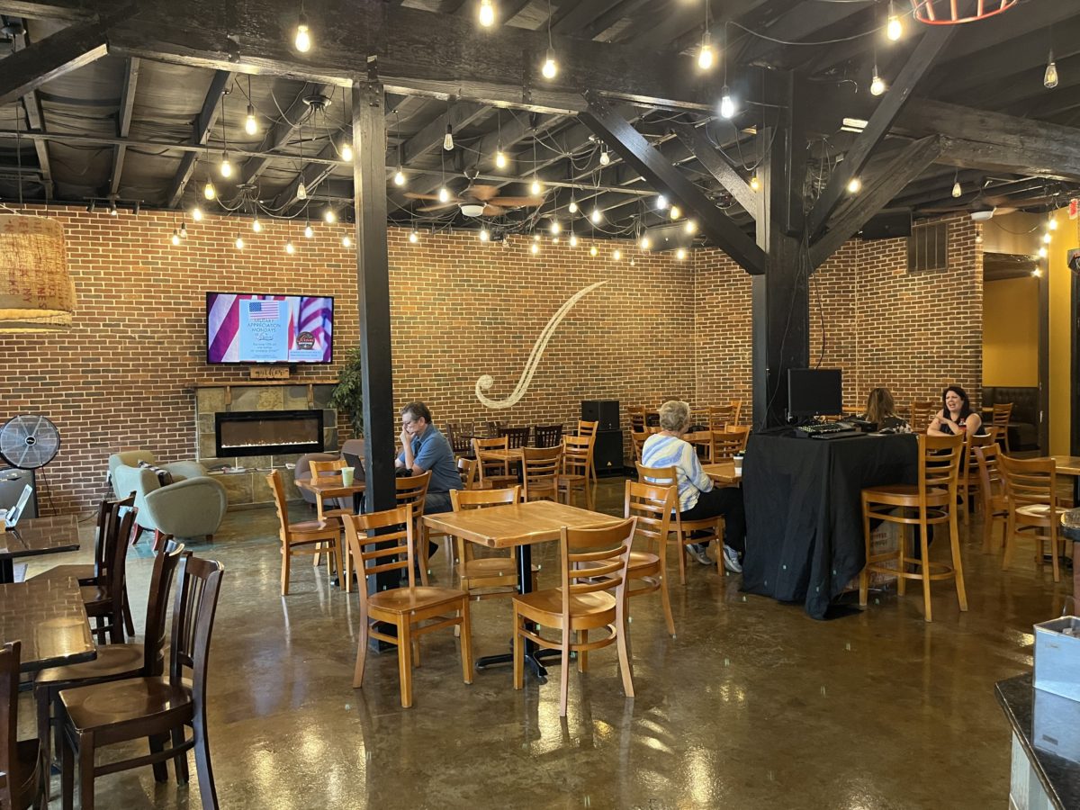 the main seating area at Jirani Coffee House: tables with chairs and couches surround a fireplace