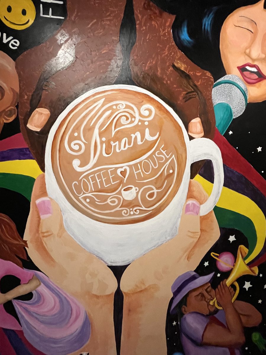the mural at Jirani Coffee House shows two hands holding a large cup of warm coffee and a musician playing the trumpet