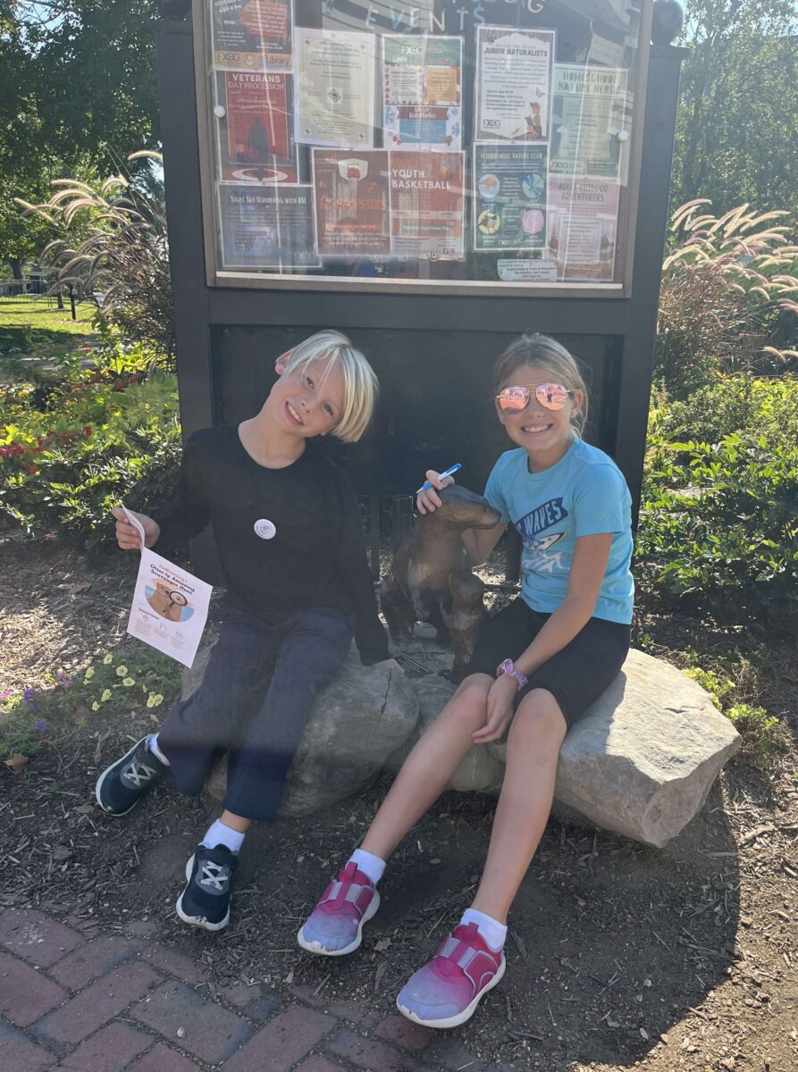 children pose with bronze otter statues in Fredericksburg, Virginia (Otterly Amazing Scavenger Hunt)